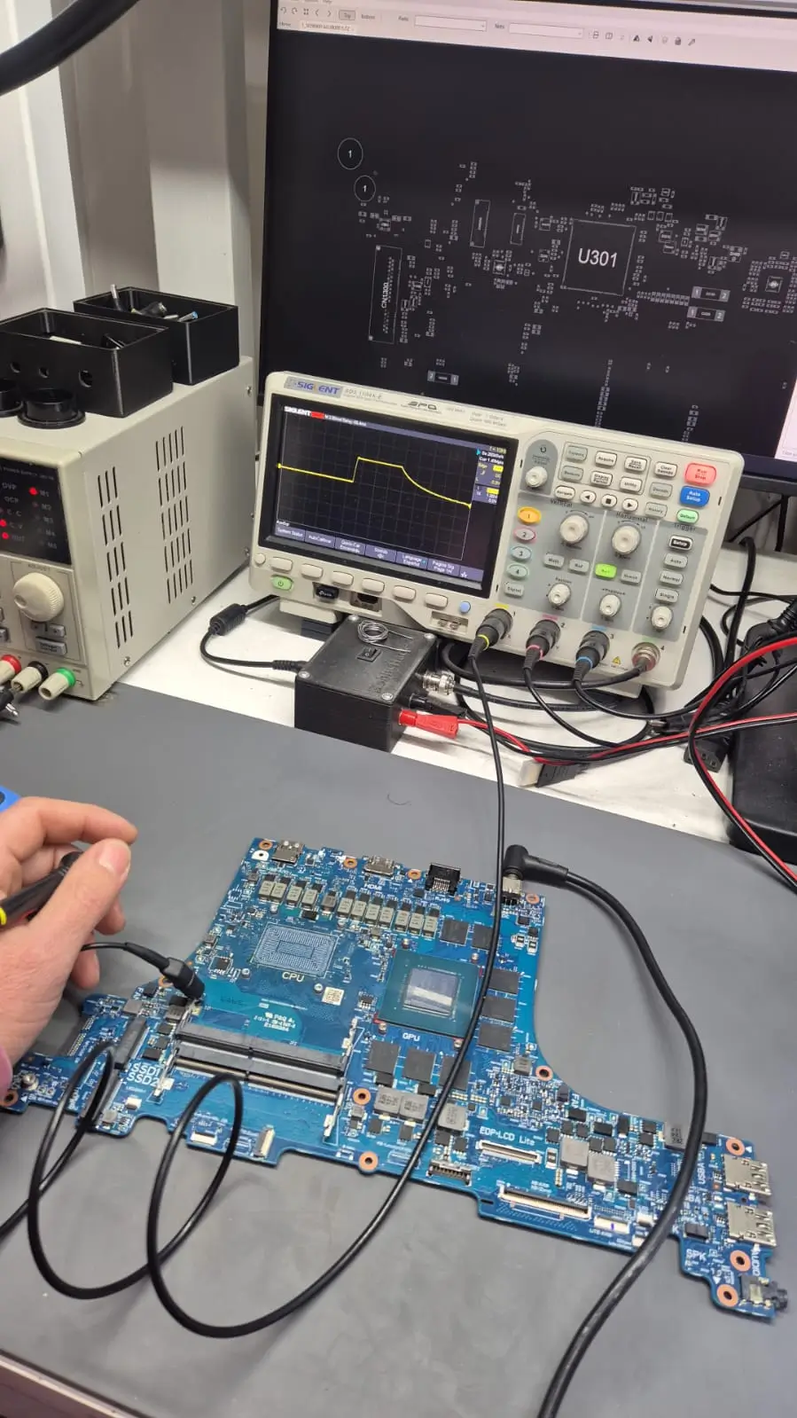 Técnico realizando diagnóstico electrónico en una placa madre de notebook