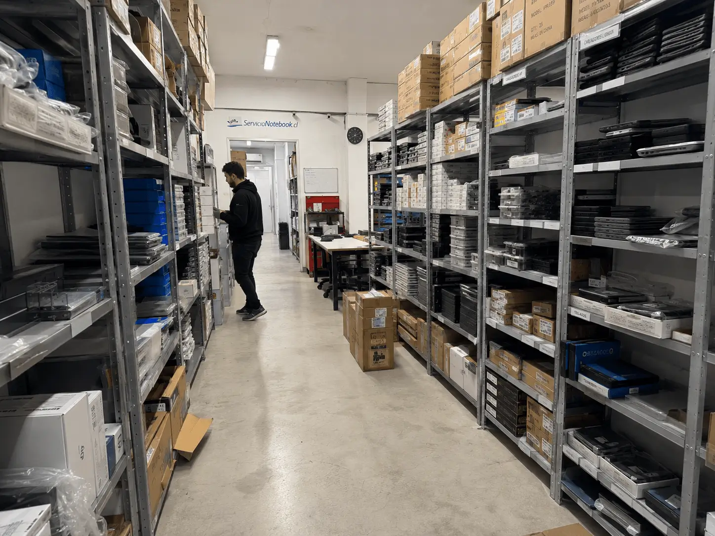 Bodega de ServicioNotebook.cl con repuestos para notebooks organizados en estanterías metálicas