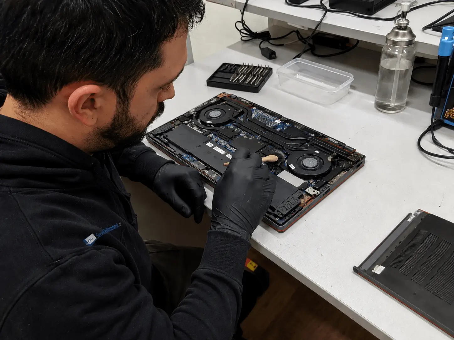 Técnico realizando mantención térmica y limpieza de un notebook abierto