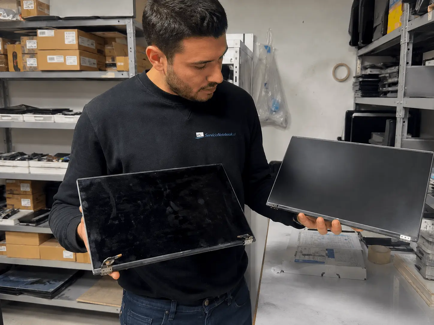 Técnico comprobando pantallas y repuestos para notebook